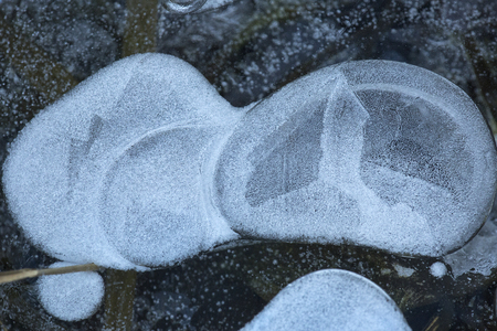 Abstract patterns and shapes in thin ice of the Hockanum River in Vernon, Connecticut, in winter.の写真素材