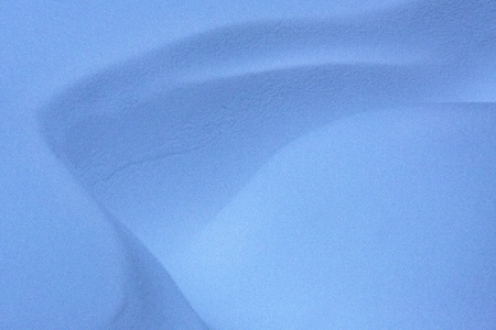 Ivory basin of light blue drifted snow, with leading lines of snow ridges in northern Maine.の写真素材