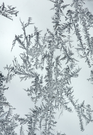 Feathery ice patterns on a frosted window in the winter in northern Maine.の写真素材
