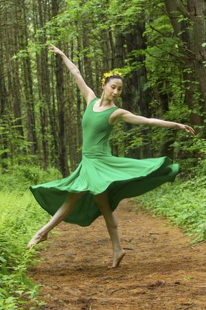 Woman in green dress,  dancing on a path in the woods, at the Belding Wildlife Management Area in Vernon, Connecticut.の写真素材