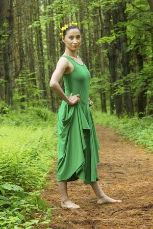 Woman dancer in green dress, standing on a path in the woods, at the Belding Wildlife Management Area in Vernon, Connecticut.の写真素材