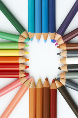 Color pencils in arrange in color wheel colors on white backgroundの写真素材
