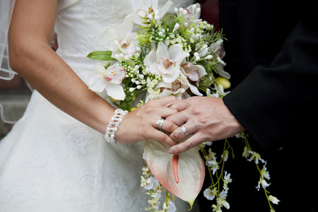 Bride and groom holding bridal bouquet close upの写真素材