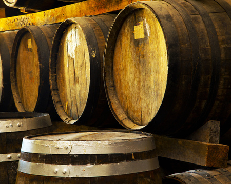 Wine barrels stacked in the old cellar of the winery.