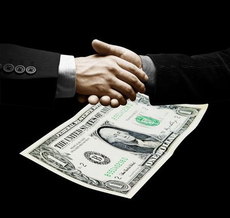 Men of business closing a treatment. One dollar in background.