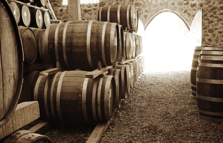 Wine barrels stacked in the old cellar of the winery.