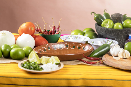Typical Mexican food dishes with sauces on colorful table. Empty clay plateの写真素材