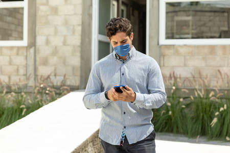 Handsome man with mouth waiting for someone in the outdoors during COVID-19 pandemicの写真素材