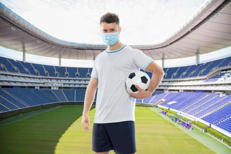 Soccer player with face masks with empty stadium in the background.
