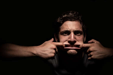 Scared man screaming out in dark backround. dramatic lightsの写真素材