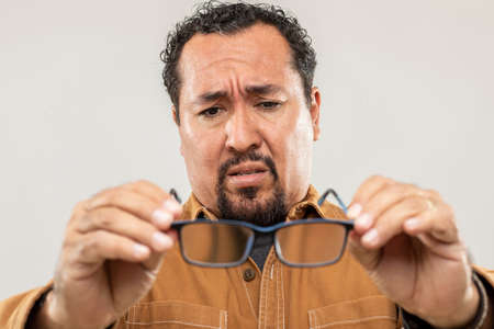 expression and people concept - Main with impaired vision with funny face over gray background....