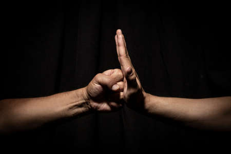 Friends hit their hands very strong in dark backround. dramatic lightsの写真素材