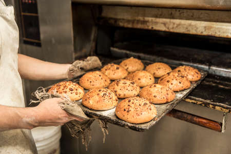 hands of the teacher baker in the bread production on the table