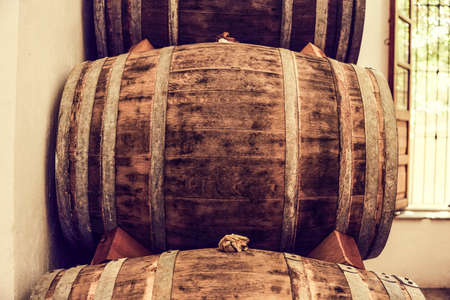 Wine barrels stacked in the old cellar of the winery.