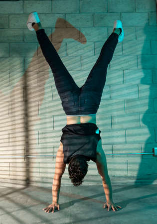 Young and attractive man practicing break dance in a cellar