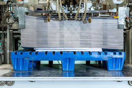 Close up of an offset printing machine during production. Stacking boxes