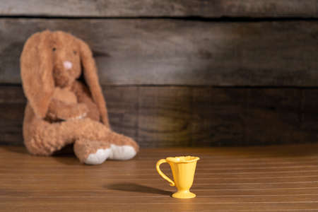 toys of a child in the house. depressed teddy bunny over the wooden tableの写真素材