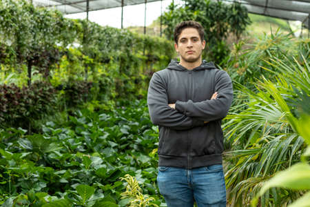 Portrait of young entrepreneur proud owner of nursery or business .. Growing house of decorative plants and vegetables.の写真素材