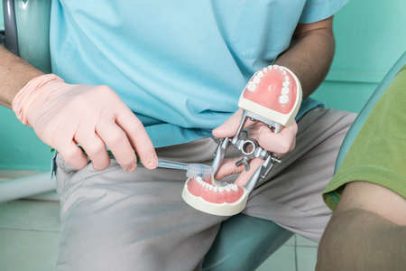 Dentist doctor and patient man in a modern dental office. Lifestyle set.