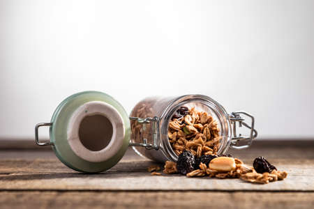 Delicious granola and oatmeal in jars on wooden table. Rustic decorationの写真素材