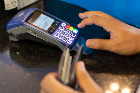 Smiling and handsome young man buying tennis for football. difficult decisionsの写真素材