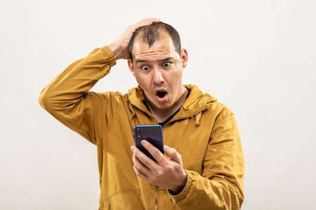 Expression session. Young man watching his cell phone with different facial expressions