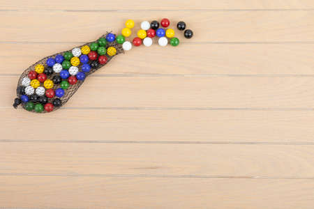 Wooden floor detail with a lot of colored marbles. kid's toys