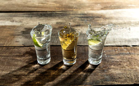 detail of tequila shot on a wooden table with blur backgroundの写真素材