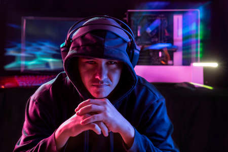 Portrait of the Young Pro Gamer Playing in Online Video Game. Neon and magenta Colored Room. e-Sport Cyber Games Internet Championship. Motion sweep in image.の写真素材
