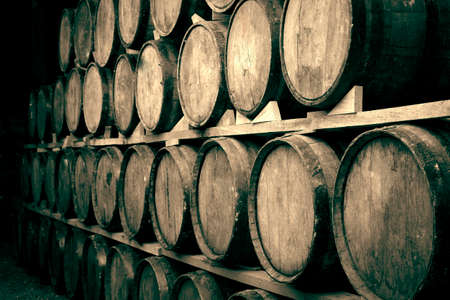 Wine barrels stacked in the old cellar of the winery.