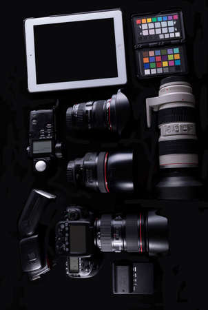 professional photographic equipment with digital camera, lenses and accessories. Dark atmosphere
