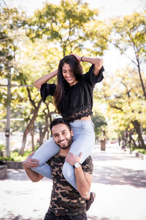 Young couple man and woman in love, having fun and kissing in the public park.の写真素材