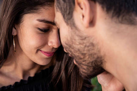 Young couple man and woman in love, having fun and kissing in the public park.