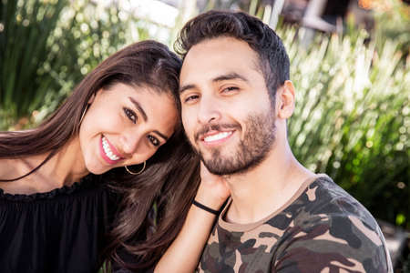 Young couple man and woman in love, having fun and kissing in the public park.の写真素材