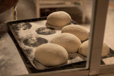 hands of the teacher baker in the bread production on the table