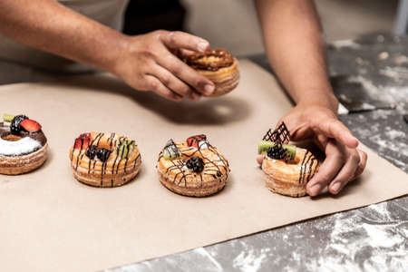 hands of the teacher baker in the bread production on the table