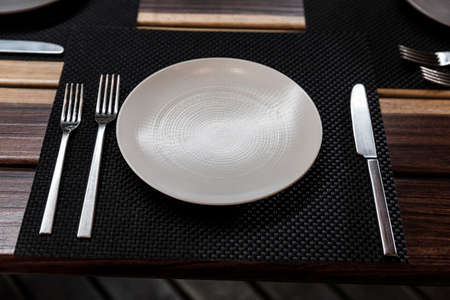 detail of plate and cutlery in a wood table after lunch