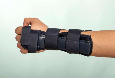 Man hand with adjustable immobilizer for injuries of bones and muscles .. Orthopedic device.human, dark,の写真素材