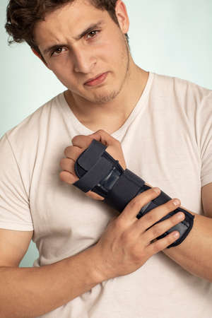 Man hand with adjustable immobilizer for injuries of bones and muscles .. Orthopedic device.human, dark,の写真素材