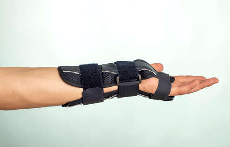 Man hand with adjustable immobilizer for injuries of bones and muscles .. Orthopedic device.human, dark,の写真素材