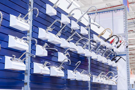 shelf detail with many different water faucets hangingの写真素材