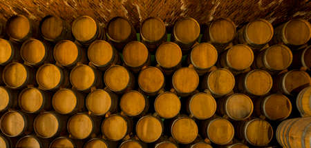 Wine barrels stacked in the old cellar of the winery.の写真素材
