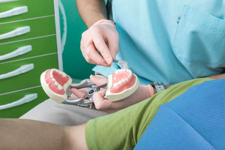 A young male dentist and a patient. Dentist office lifestyle scene. Doctor practice. Patient health...