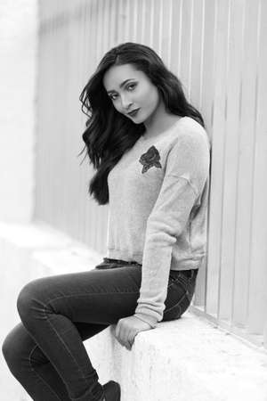 Beautiful young woman wearing fashionable clothes walking on the street