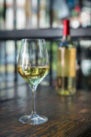 Bottle and white wine glass in white background