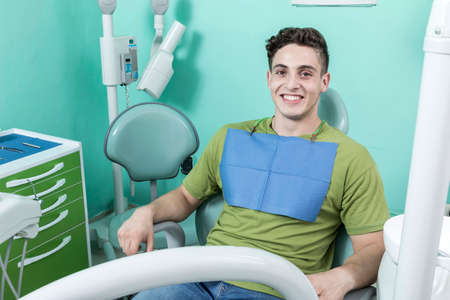 A young male dentist and a patient. Dentist office lifestyle scene. Doctor practice. Patient health careの写真素材