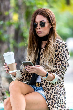 Beautiful young woman wearing fashionable clothes walking on the streetの写真素材