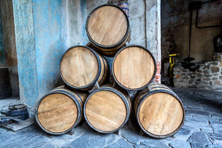 Wine barrels stacked in the old cellar of the winery.