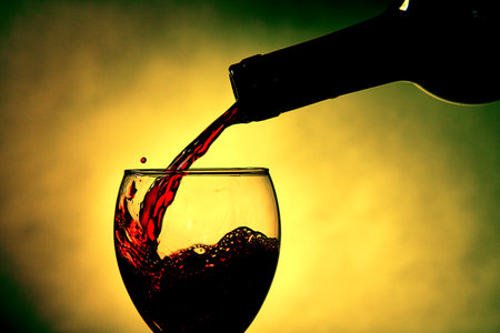 Bottle and wine glass in yellow back ground