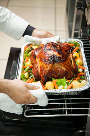 Hands of cook preparing roasted chicken with saladの写真素材